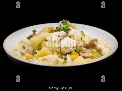 A  bowl of chowder made from pollack, Pollachius pollachius, diced smoked bacon, potatoes, celery, sweetcorn, onion, single cream, fish stock and flav Stock Photo