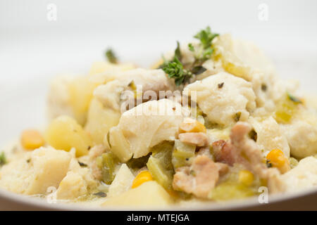 A  bowl of chowder made from pollack, Pollachius pollachius, diced smoked bacon, potatoes, celery, sweetcorn, onion, single cream, fish stock and flav Stock Photo