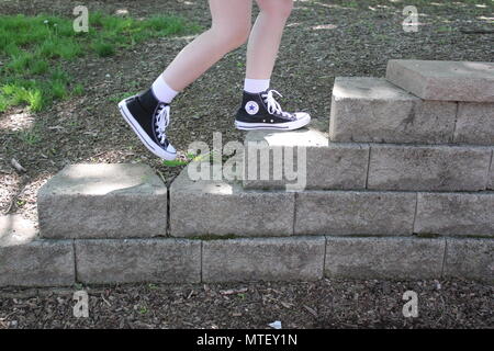 in beroep gaan Botsing schuld Teenaged girl walking up and down the stairs wearing white socks and a pair  of black converse sneaker high-tops Stock Photo - Alamy