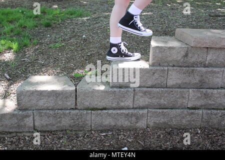 Teenaged girl walking up and down the stairs wearing white socks and a pair  of black converse sneaker high-tops Stock Photo - Alamy