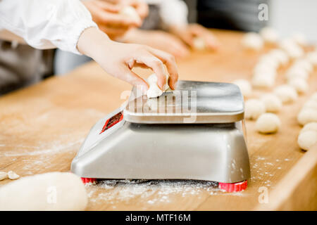 baker weighing bread dough on scale at bakery Stock Photo - Alamy