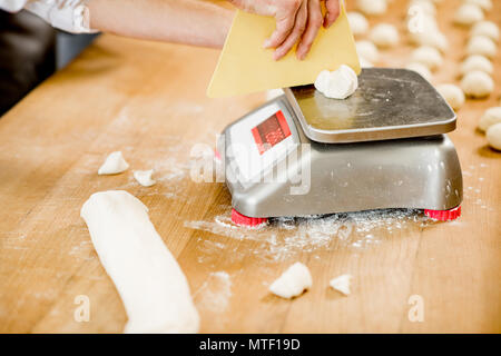 baker weighing bread dough on scale at bakery Stock Photo - Alamy