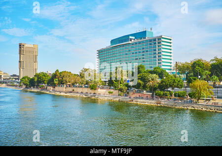 The view on Corniche embankment of Cairo Downtown from the Qasr El Nil bridge, the modern tourist hotels are seen behind the lush greenery of riversid Stock Photo