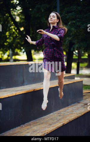 Girl does pirouette walking on a tiptoes against summer park. Stock Photo