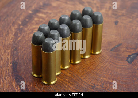 Revolver cartridges .45 Cal Wild West period on wooden background Stock Photo