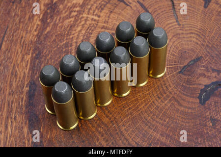 Revolver cartridges .45 Cal Wild West period on wooden background Stock Photo