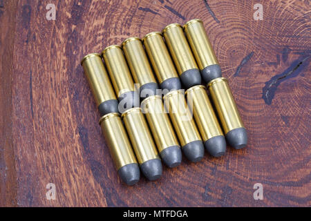 Revolver cartridges .45 Cal Wild West period on wooden background Stock Photo