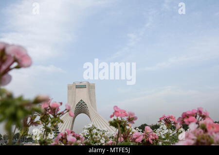 TEHRAN, IRAN - 7 May  2018. The Azadi Tower behind pink and white geranium cranesbill flowers, spring season Stock Photo