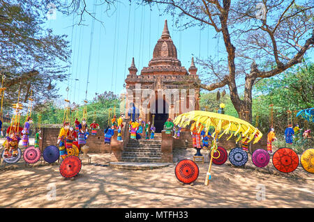 Myanmar beautiful handcrafted umbrellas and hanged puppets attracts tourists to toy exhibition market next to ancient shrines in Bagan Stock Photo