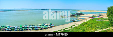 The panoramic view on Irrawaddy river and moored small boats and tourist multi-decked ships in Old Bagan, Myanmar Stock Photo