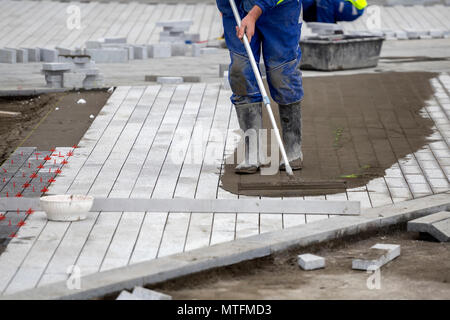 Install paver sidewalk with paving stones, using spacers to achieve ...