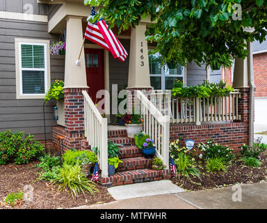 HICKORY, NC, USA-27 MAY 18:  A colorful house front, with green, blue, orange, and red.  A small American flag on either side of steps, and a larger o Stock Photo