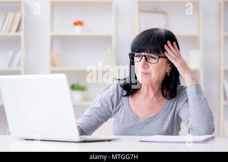 Senior woman struggling at computer Stock Photo