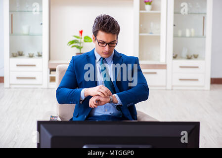 Businesman watching tv in office Stock Photo