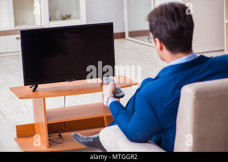 Businesman watching tv in office Stock Photo