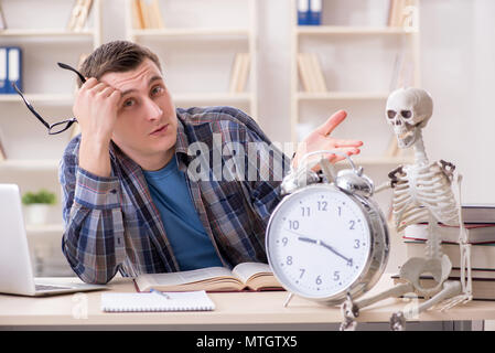 Student and skeleton preparing for school exams Stock Photo