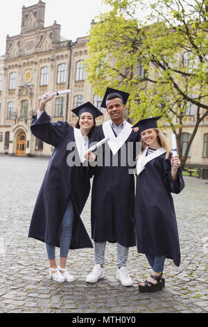 Three happy graduates posing for memorable photo Stock Photo