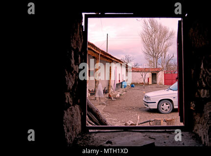 View of backyard of an old country house through window of old grunge barn Stock Photo