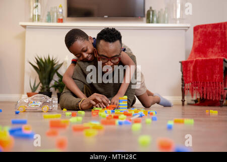 Father and son playing with toys on the floor Stock Photo