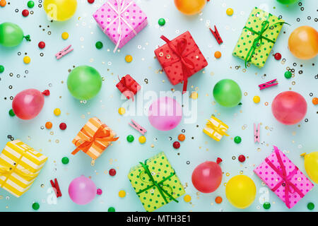 Fashion party background with colorful gift boxes on blue background. Gift boxes wrapped in striped and polka dots colorful paper and tied with bows.  Stock Photo