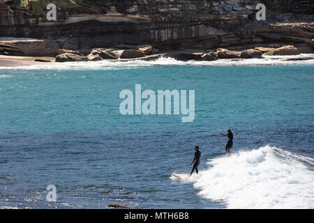 Surfers catching the waves at Bronte Beach in Sydney, New South Wales, Australia Stock Photo