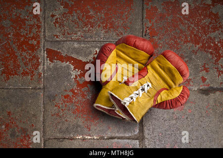 Old boxing gloves on grunge background floor Stock Photo