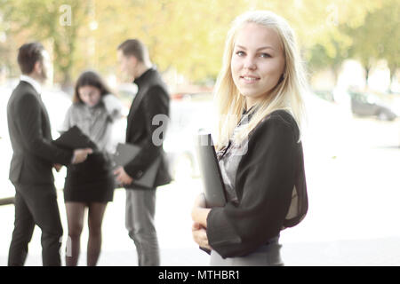 young business woman with clipboard standing outdoors near office Stock Photo