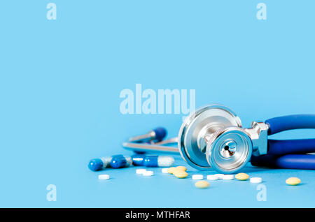 Stethoscope and pills on blue background copy space Stock Photo