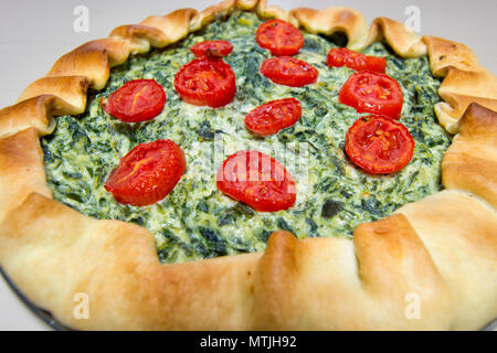 vegetarian salad cake with puff pastry, spinach, ricotta cheese and tomatoes Stock Photo