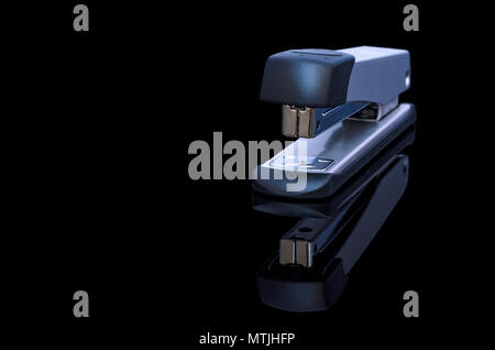 Metalic stapler on black background with copy space Stock Photo