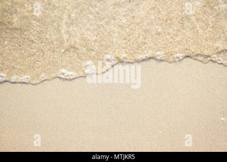 Soft clear sea wave on the beach sand background. Stock Photo