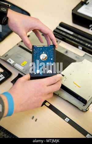 A technician holding a laptop hard drive Stock Photo
