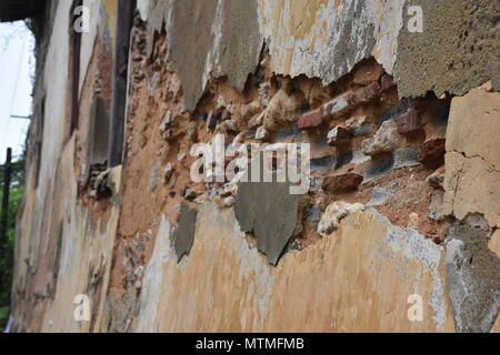 Weathered Old Wall with Exposed Bricks and Peeling Plaster Texture Stock Photo