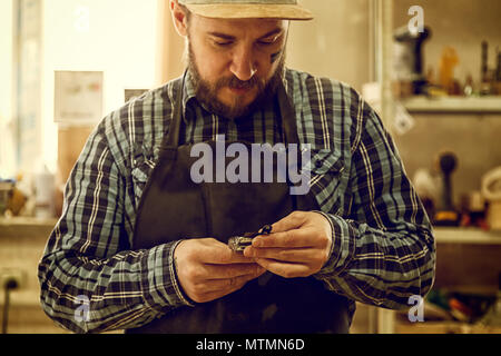 Close up of a experienced carpenter in work clothes and small buiness owner working in woodwork workshop Stock Photo