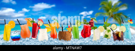 row of various colorful cocktails and long drink beverages in crushed ice cubes isolated on tropical palm beach ocean paradise background Stock Photo