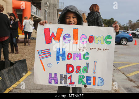 Son of PO1 Scott Reid shows off the sign him and his brother made for the return of their father at Camp Lejeune, N.C., Jan. 10, 2017. Reid was on a nine-month deployment with Special Purpose Marine Air-Ground Task Force Crisis Response-Africa; a rotation in place to protect U.S. personnel, property and interests in Europe and Africa. Reid is a Corpsman with 2nd Marine Logistics Group. (U.S. Marine Corps photo by Lance Cpl. Miranda Faughn) Stock Photo