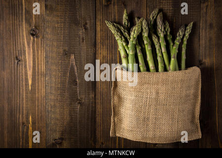 Green Asparagus in Juta Bag on White Wooden Table Stock Photo