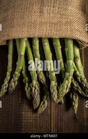 Green Asparagus in Juta Bag on White Wooden Table Stock Photo