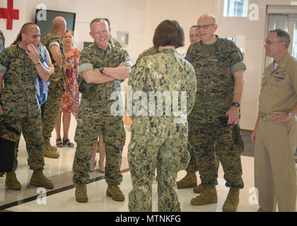 U.S. Navy Hospital Corpsman 2nd Class Stephanie Swogger (middle), a mortician at US Naval Hospital Guam, shares the details of her duty with U.S. Marine Corps Lt. Gen. Lawrence D. Nicholson, Commanding General, III Marine Expeditionary Force.  Because of how many retiree and veteran patients come to the hospital from the local population, the morticians at US Naval Hospital Guam are some of the busiest in the entire Department of Defense. (U.S. Navy photo by USNH Guam Public Affairs/Released) Stock Photo