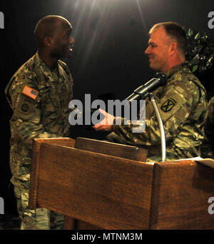 Col. Shawn Schuldt, commander of the 10th Mountain Division (LI) Sustainment Brigade, presents a token of appreciation to Brig. Gen. Xavier Brunson, 10th Mountain Division (LI) Deputy Commanding General, following Brunson's speech at the 'Remember, Celebrate, Act' event in honor of Dr. Martin Luther King Jr. at the Fort Drum Commons on January 11, 2017. Approximately 200 Soldiers and members of the Fort Drum community attended the event. Stock Photo