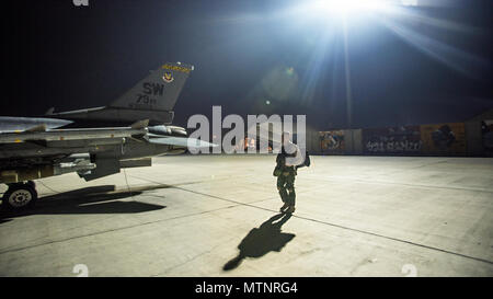 Capt. David, 79th Expeditionary Fighter Squadron pilot, walks out to an F-16 Fighting Falcon before a night mission Jan. 13, 2017 at Bagram Airfield, Afghanistan. David enlisted in the Air Force in 2004 as an F-16 avionics specialist and now flies the same airframe he used to maintain. (U.S. Air Force photo by Staff Sgt. Katherine Spessa) Stock Photo