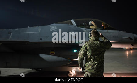 Capt. David, 79th Expeditionary Fighter Squadron pilot, and Staff Sgt. Daniel Lasal, 455th Expeditionary Aircraft Maintenance Squadron dedicated crew chief, salute one another before a night mission Jan. 13, 2017 at Bagram Airfield, Afghanistan. David enlisted in the Air Force in 2004 as an F-16 Fighting Falcon avionics specialist and now flies the same airframe he used to be a maintainer for. (U.S. Air Force photo by Staff Sgt. Katherine Spessa) Stock Photo