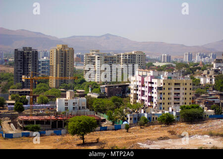 Aerial view of city scape with apartment buildings, under construction buildings and mountains Stock Photo