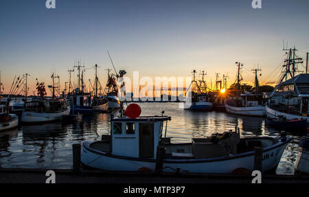 small fishing motor boats lined up in a fishing sea harbor in the evening  with puffy clouds in the sky Stock Photo - Alamy