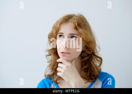 Indoor portrait of young beautiful redhead European female isolated on white background wearing blue T-shirt Stock Photo