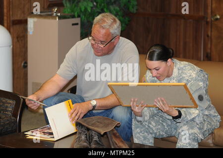 Sgt. Angela Myers, 311th ESC ammunition sergeant, looks over photos she's never seen with her Uncle Corey Rose. This is Myers first time meeting her uncle or any biological family. She was raised in foster care. Stock Photo