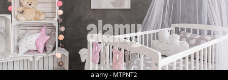 Baby room with a simple wooden furniture, stylish decorations and cement wall design Stock Photo