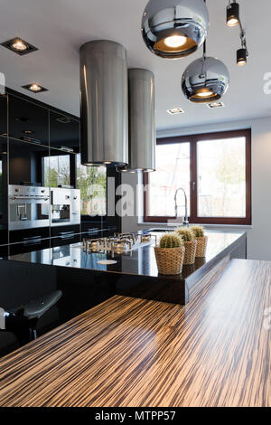 Black high-gloss open kitchen with lighting in modern style Stock Photo