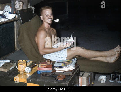 North Danger Island is a small coral cay in the Spratly Islands of the South China Sea. The archival image documents a United States Air Force member assigned to the 1374th Mapping and Charting Squadron stationed on North Danger Island in 1956, where radar and radio relay personnel supported electronic geodetic survey and mapping operations from a temporary tent encampment. Stock Photo
