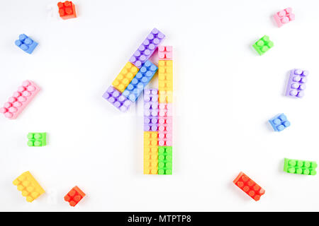 Colorful plastic blocks forming the number one on white background. Stock Photo
